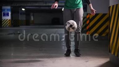 一个年轻人在地下停车场训练足球技能